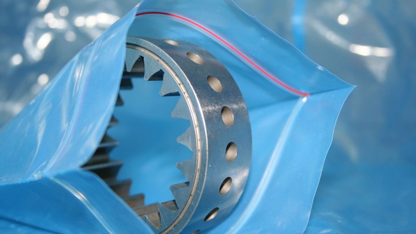 Metal gear or precision component packaged in blue VCI film. The VCI anti-corrosion film reliably protects metal parts from rust and corrosion during storage, transport and export packaging.
