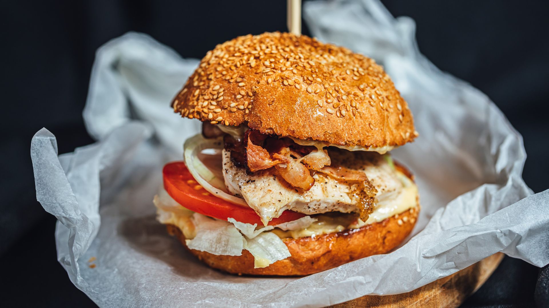 Burger in Blechrein Einschlagpapier, das vor Durchfetten schützt und einen sauberen Genuss unterwegs ermöglicht.